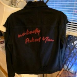 Black denim jacket with Nobody Asked  You  embroidered on it